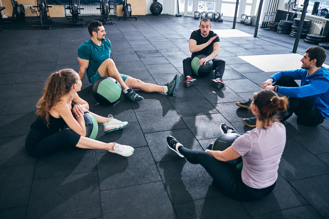 Four athletes listening to their fitness coach